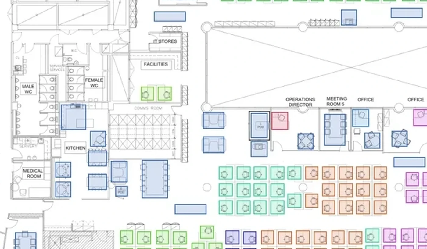 A close-up of a general arrangement drawing: walls, doors, WC cubicles, furniture blocks and hatched cores